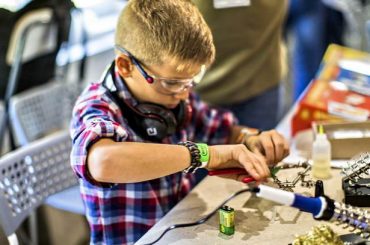 Mini Maker Faire, мальчик паяет, ребенок изобретатль, ребенок делает робота