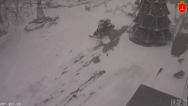 Трактор борется со снегом возле мэрии